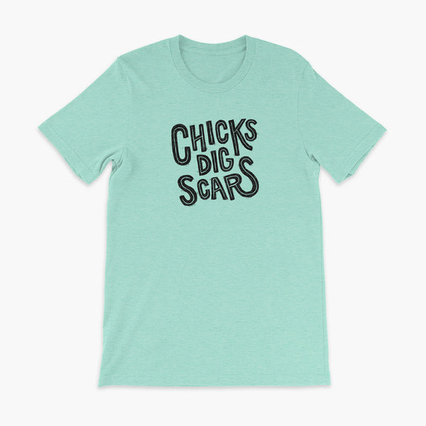Black textured and distressed hand lettered typography that says chicks dig scars on a heather mint t-shirt