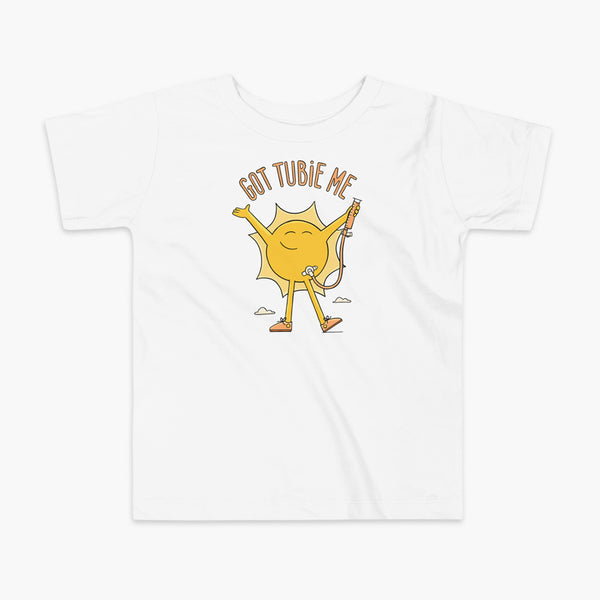 A happy sun stands confidently in tennis shoes holding a g-tube or a gastronomy tube with a stoma for StomaStoma with the text Got Tubie Me above him on a kids white t-shirt 
