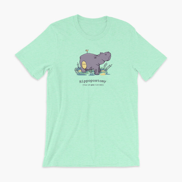 A Hippo or Hippopotamus with an ostomy bag — also known as a Hippopostomy. He is standing in some foliage smiling and has a bird on his back on a heather mint adult t-shirt.