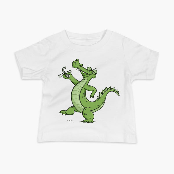 A green alligator or crocodile walks confidently with a big smile after bing decannulated of trach free. It is holding the trach in his hand. One a white infant t-shirt