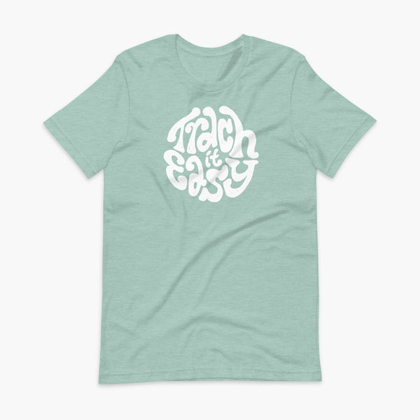 White text that says Trach It Easy for living the tracheostomy life with StomaStoma on a heather prims dusty light blue adult t-shirt 