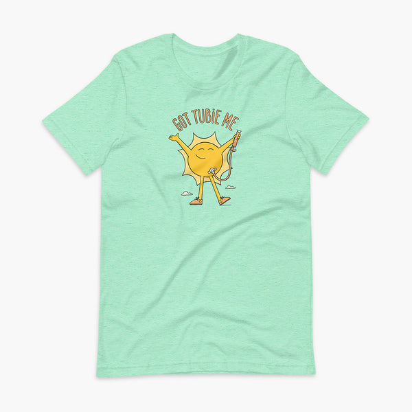 A happy sun stands confidently in tennis shoes holding a g-tube or a gastronomy tube with a stoma for StomaStoma with the text Got Tubie Me above him on an adult heather mint t-shirt 