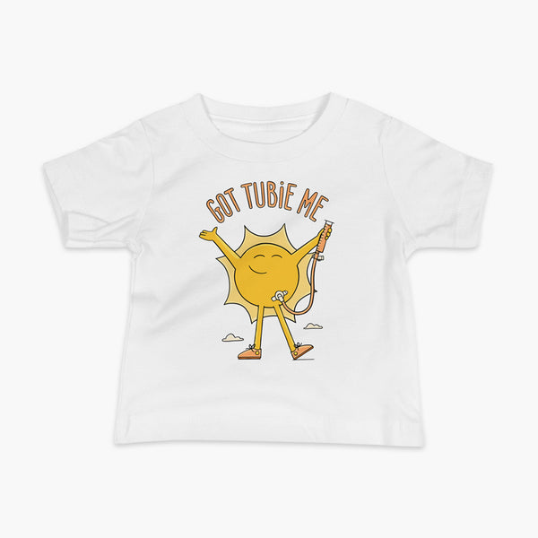 A happy sun stands confidently in tennis shoes holding a g-tube or a gastronomy tube with a stoma for StomaStoma with the text Got Tubie Me above him on a infant white t-shirt 