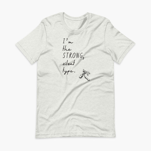 Handwritten text that say I’m the Strong Silent Type with an illustration of a trach - a bivona flextend trach with a cuff on a Heather ash adult t-shirt
