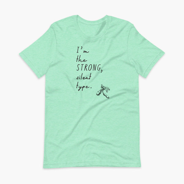 Handwritten text that say I’m the Strong Silent Type with an illustration of a trach - a bivona flextend trach with a cuff on a heather mint adult t-shirt