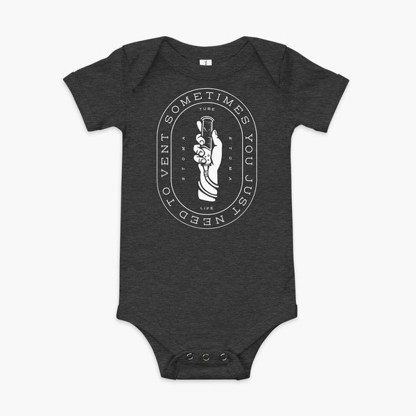 Text that says Sometimes You Just Need To Vent wrapping around a hand holding a syringe or venting tube that is connected to a g-tube or gastronomy tube and mic-key button. There is additional text that says StomaStoma and Tube Life. On a dark grey heather infant onesie