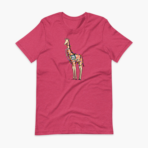 A Christmas giraffe with a trach or tracheostomy and a ventilator and g-tube mic-key button standing in a shrubbery covered in strings of Christmas lights with a stoma on a heather raspberry adult t-shirt