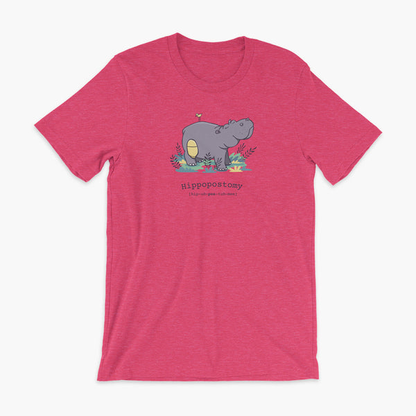 A Hippo or Hippopotamus with an ostomy bag — also known as a Hippopostomy. He is standing in some foliage smiling and has a bird on his back on a heather raspberry adult t-shirt.