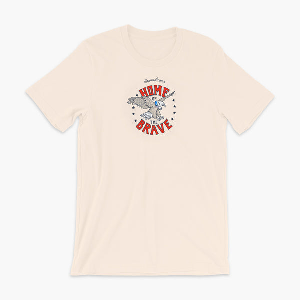 A patriotic American bald eagle with a trach or tracheostomy for the 4th of July and the words StomaStoma Home of the Brave and stars on a soft creme adult t-shirt
