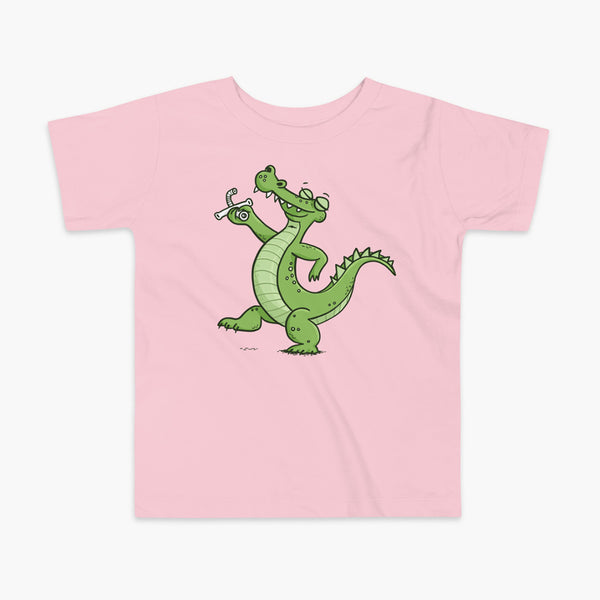 an alligator or crocodile that was decannulated or just got its trach or tracheostomy out  on a pink kids t-shirt
