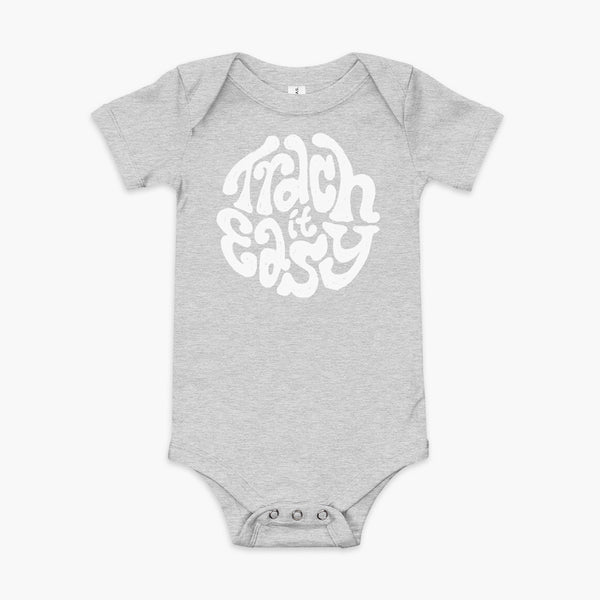 White text that says Trach It Easy for living the tracheostomy life with StomaStoma on a heather athletic grey infant onesie