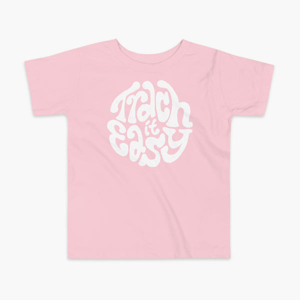 White text that says Trach It Easy for living the tracheostomy life with StomaStoma on a pink kids t-shirt