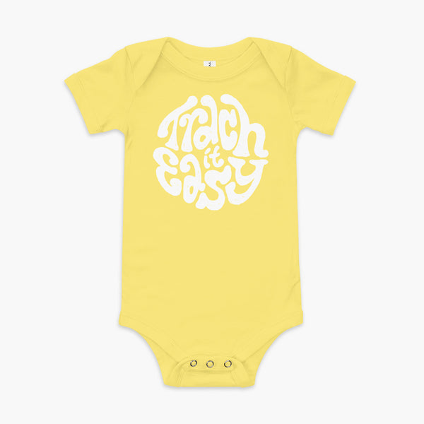 White text that says Trach It Easy for living the tracheostomy life with StomaStoma on a yellow infant onesie