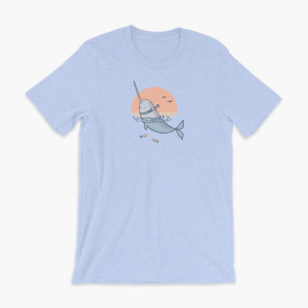 A Narwhal that has a trach or tracheostomy pokes his head and horn through the water in front of a setting sun. He has a naturally built in stoma. It is on a heather blue adult t-shirt.