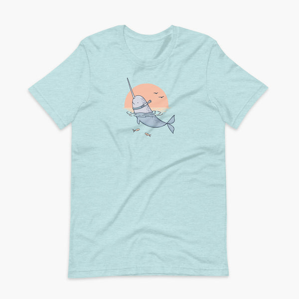 A Narwhal that has a trach or tracheostomy pokes his head and horn through the water in front of a setting sun. He has a naturally built in stoma. It is on a heather ice blue adult t-shirt.