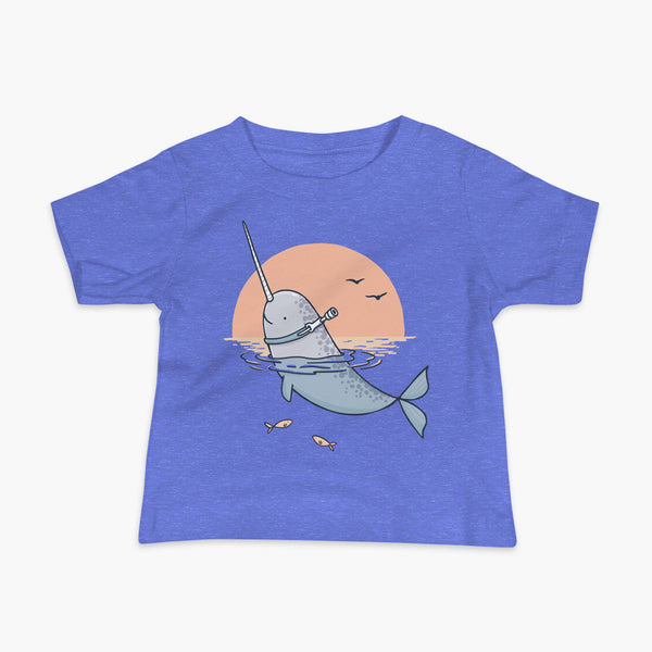 A Narwhal that has a trach or tracheostomy pokes his head and horn through the water in front of a setting sun. He has a naturally built in stoma. It is on a heather blue infant t-shirt.