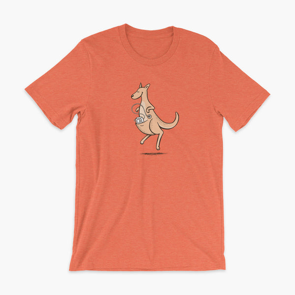A happy orange tube kangaroo hops along with her Joey feeding pump and feeding tube sitting in her pouch with a g-tube on a heather orange adult t-shirt