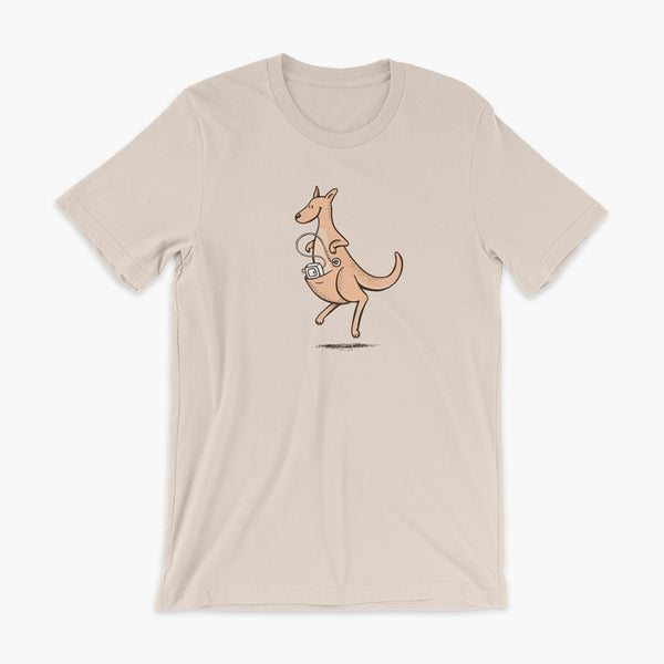 A happy orange tube kangaroo hops along with her Joey feeding pump and feeding tube sitting in her pouch with a g-tube on a soft cream adult t-shirt
