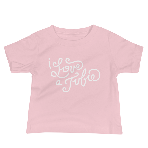 White Hand-drawn script or lettering that says I love a tubie on a  pink infant t-shirt for the g-tube or stoma.