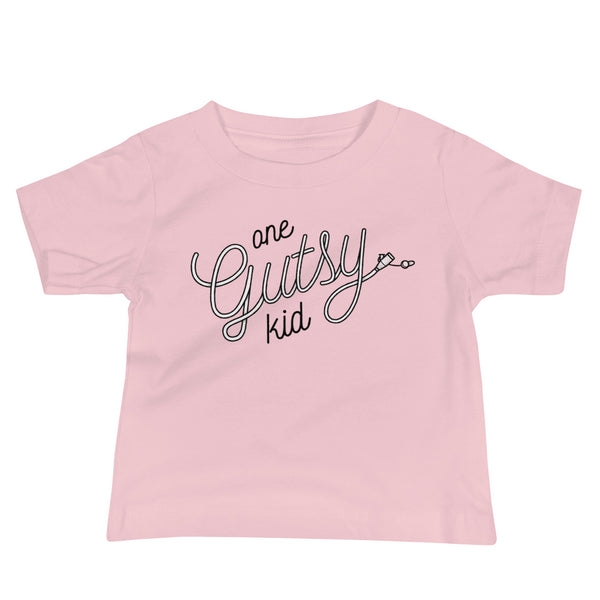 Script text that says one gutsy kid out of a g-tube or feeding tube in the stoma for a tubie life by StomaStoma on a pink infant t-shirt
