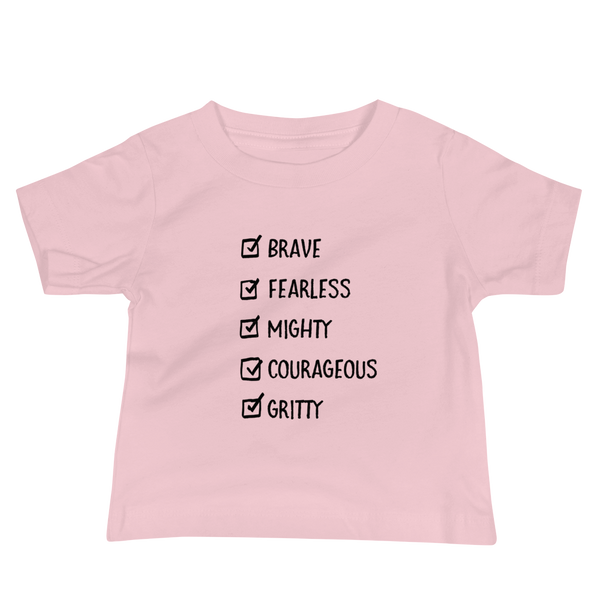A checklist of text all checked off with the words brave, fearless, mighty, courageous, gritty on a pink infant t-shirt