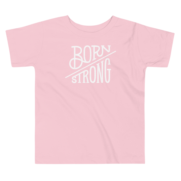The text Born Strong on a kids pink T-Shirt  by StomaStoma for g-tube and trach life empowerment.