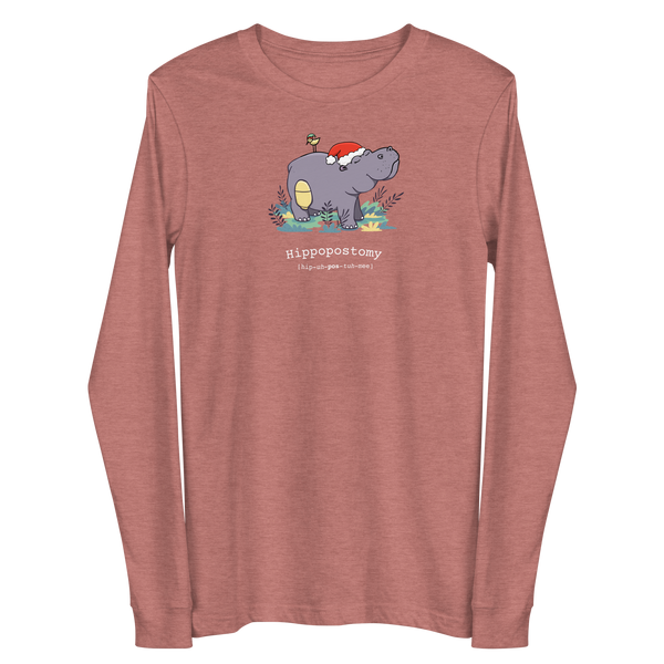 A Hippo or Hippopotamus with an ostomy bag — also known as a Hippopostomy. He is standing in some foliage smiling and has a bird on his back with a Christmas hat on a heather mauve adult long sleeve t-shirt.
