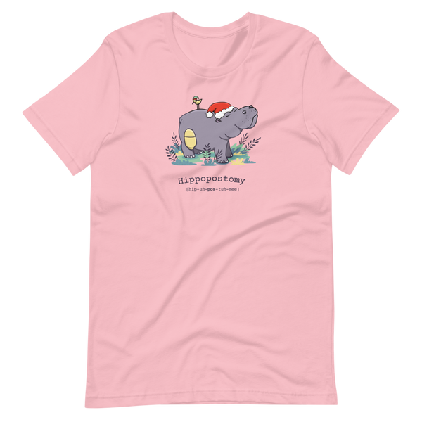A Hippo or Hippopotamus with an ostomy bag — also known as a Hippopostomy. He is standing in some foliage smiling and has a bird on his back with a Christmas hat on a pink adult t-shirt.