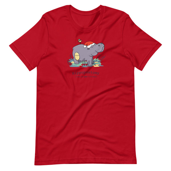 A Hippo or Hippopotamus with an ostomy bag — also known as a Hippopostomy. He is standing in some foliage smiling and has a bird on his back with a Christmas hat on a red adult t-shirt.